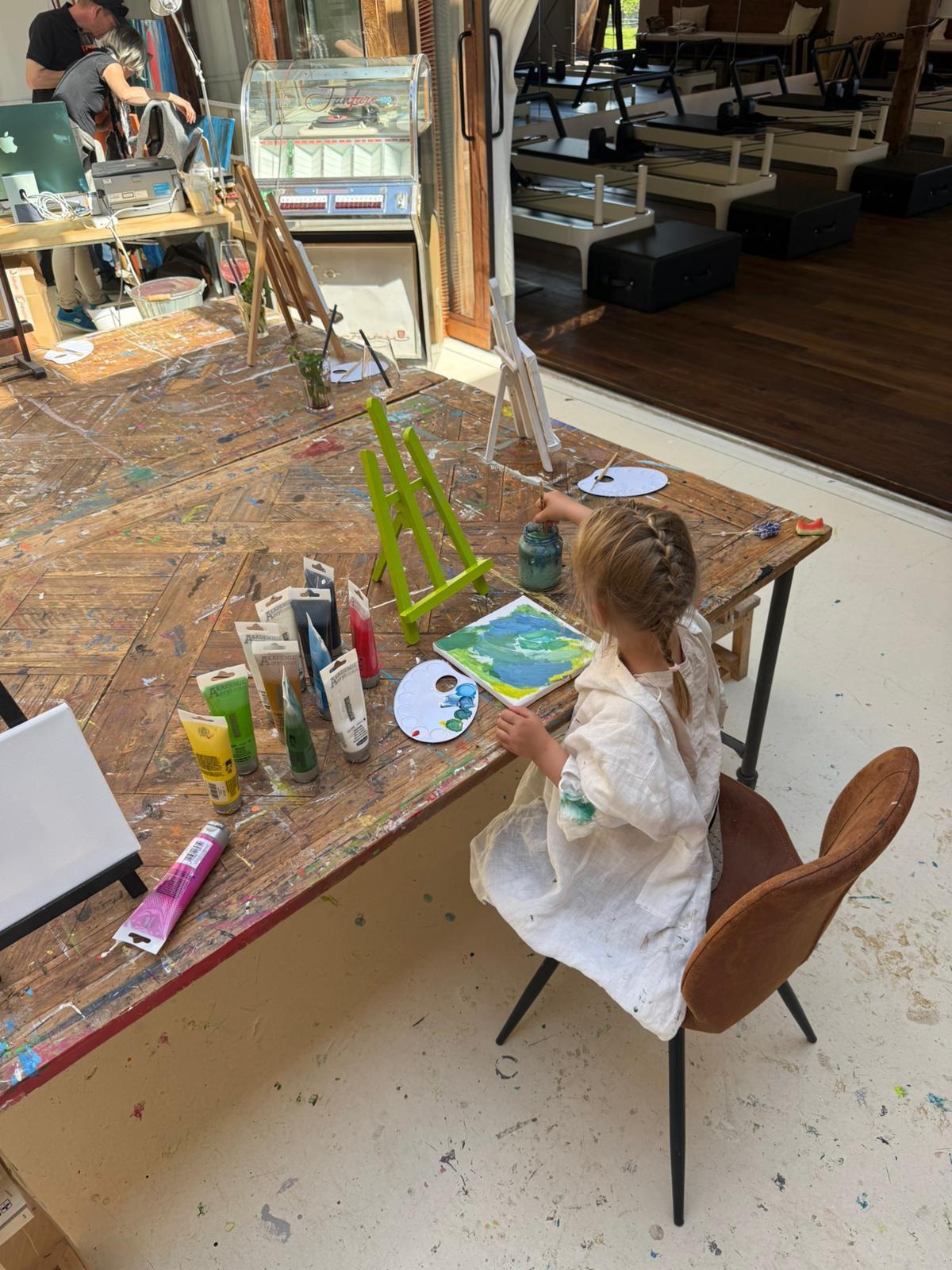 Kind beim Malen im Atelier des OFFStudio mit Farben und Pinsel